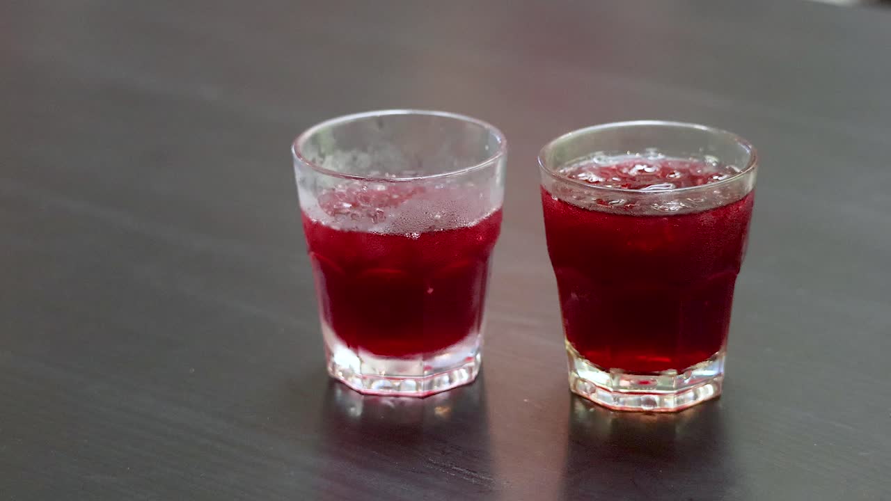 태국에서 손으로 로젤 주스 컵을 테이블에 놓는 것