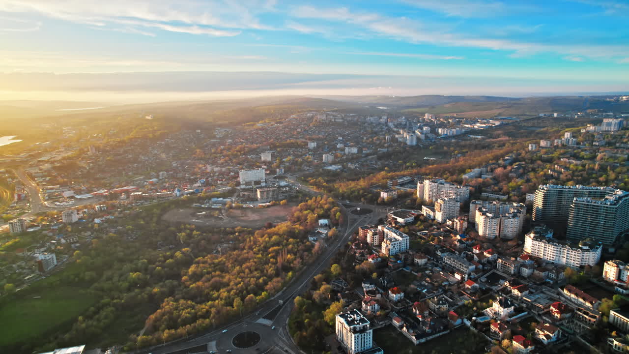 Lotniczy widok z drona na Kiszyniów o zachodzie słońca, Mołdawia. Dzielnica mieszkaniowa z wieloma budynkami, zielenią i drogami z samochodami