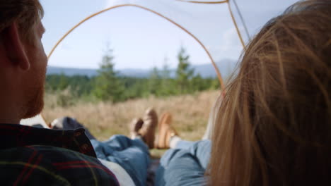 man and woman lying in camping tent