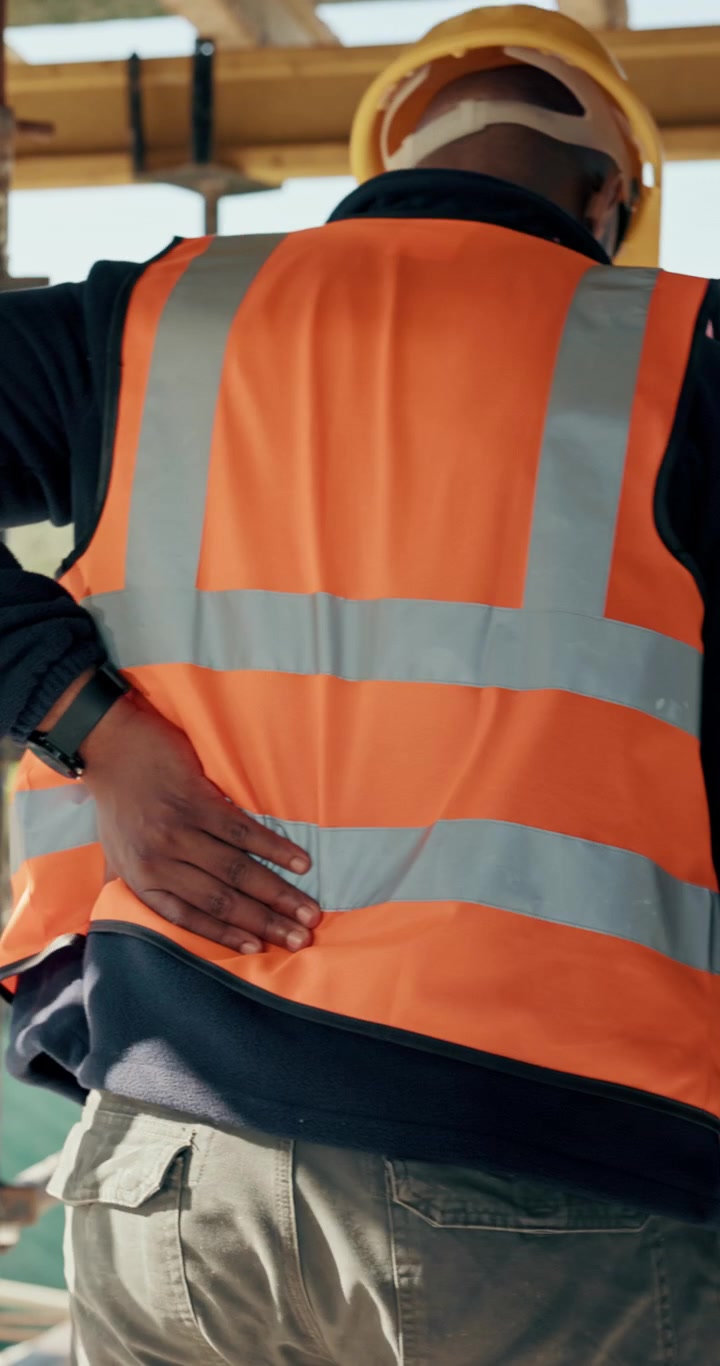 Trabajador de la Construcción Sufriendo de Dolor de Espalda en la Obra