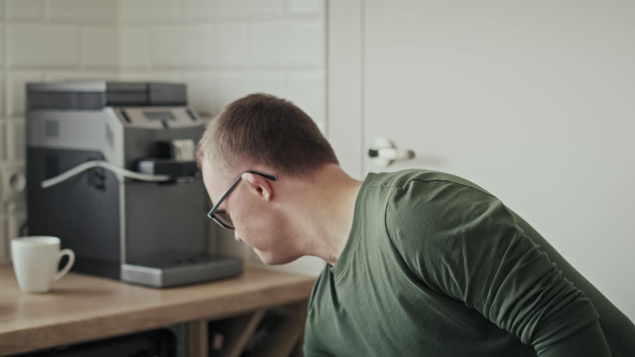 Caucasian adult man with down syndrome and his mother loading dish washer at home