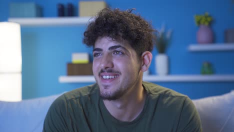 Close-up-of-happy-and-cheerful-young-man-at-home-at-night.