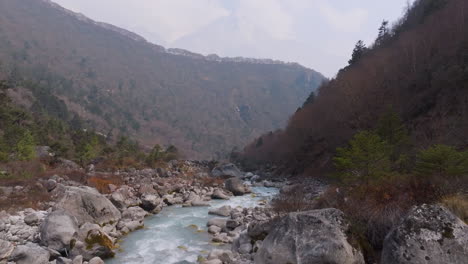 drone shot of dudh koshi river flowing freely through hills in everest region, nepal. serene landscape perfect for cinematic travel and adventurous tourism experience