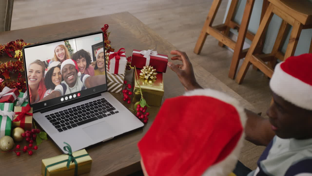 pareja diversa teniendo videoconferencia de navidad con personas diversas
