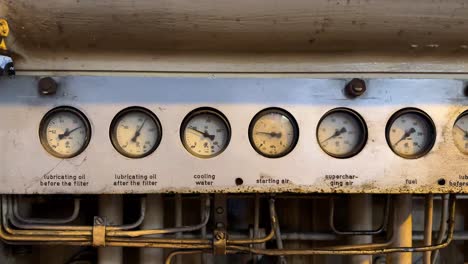 Row of Vintage analog gauge pressure running over old generator machine in manufacturing factory.