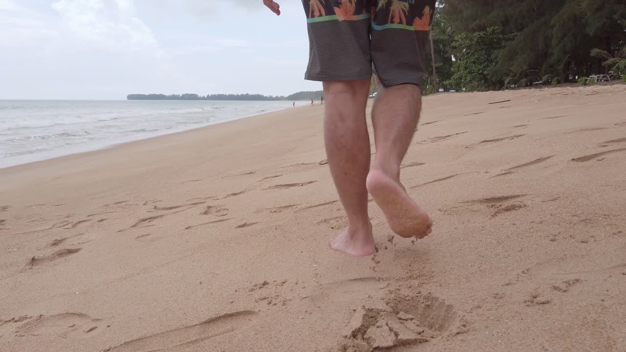 pov de hombre caminando descalzo en la playa de arena blanca en cámara lenta en vacaciones de verano
