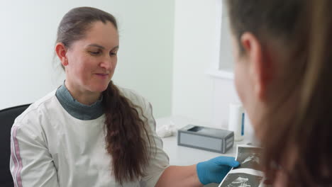 lab scientist explaining test results to patient with a smile, patient nodding in approval of the favorable results, demonstrating a positive doctor-patient interaction in a clinical setting