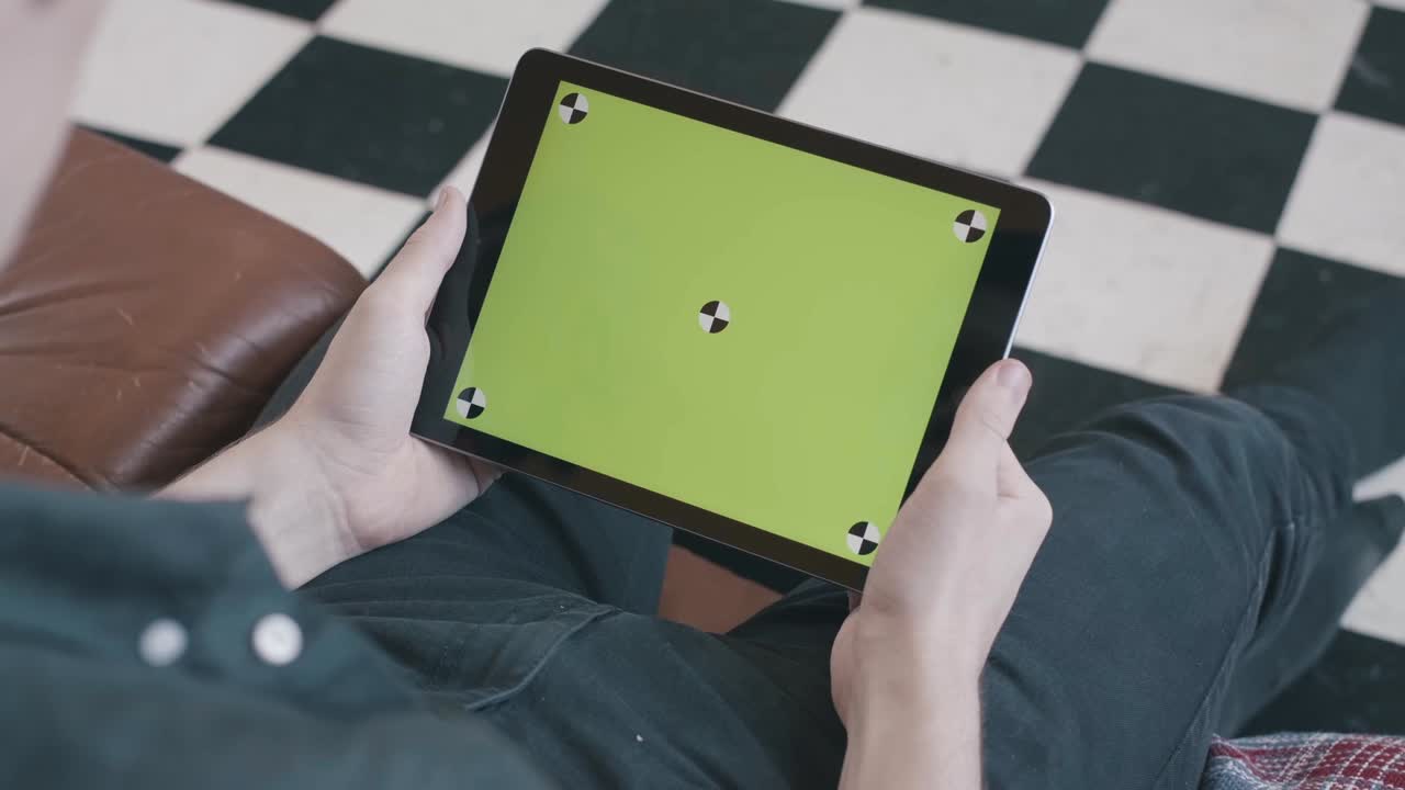 녹색 화면 을 가진 태블릿 을 들고 있는 사람