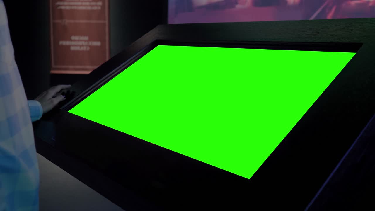 Green screen concept - woman looking at blank interactive green display kiosk