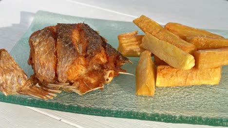 corvina frita con un lado de yuca, comida fresca peruana gourmet