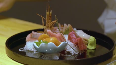 chef decorating chinese food in a tray before serving - close up