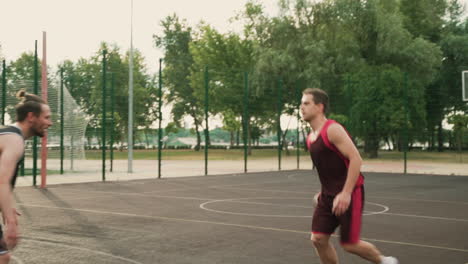 Hábil-Jugador-De-Baloncesto-Masculino-Regateando-La-Pelota-Contra-El-Defensor-Contrario-Y-Lanzando-La-Pelota-Al-Aro-2