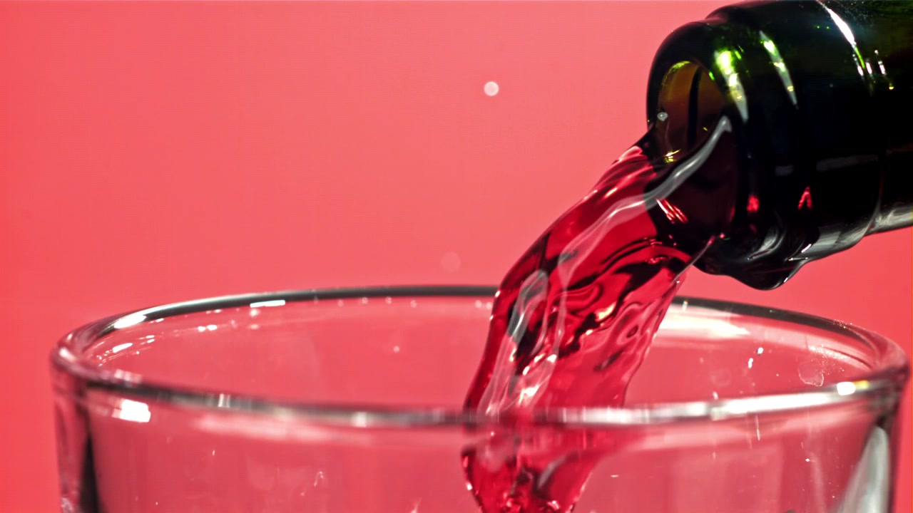 Versamento al rallentatore di vino rosso in un bicchiere