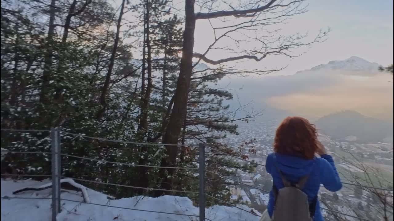 한 여성 이 스위스 의 인터라켄 계곡 을 스마트폰 으로 사진 을 찍고 있다