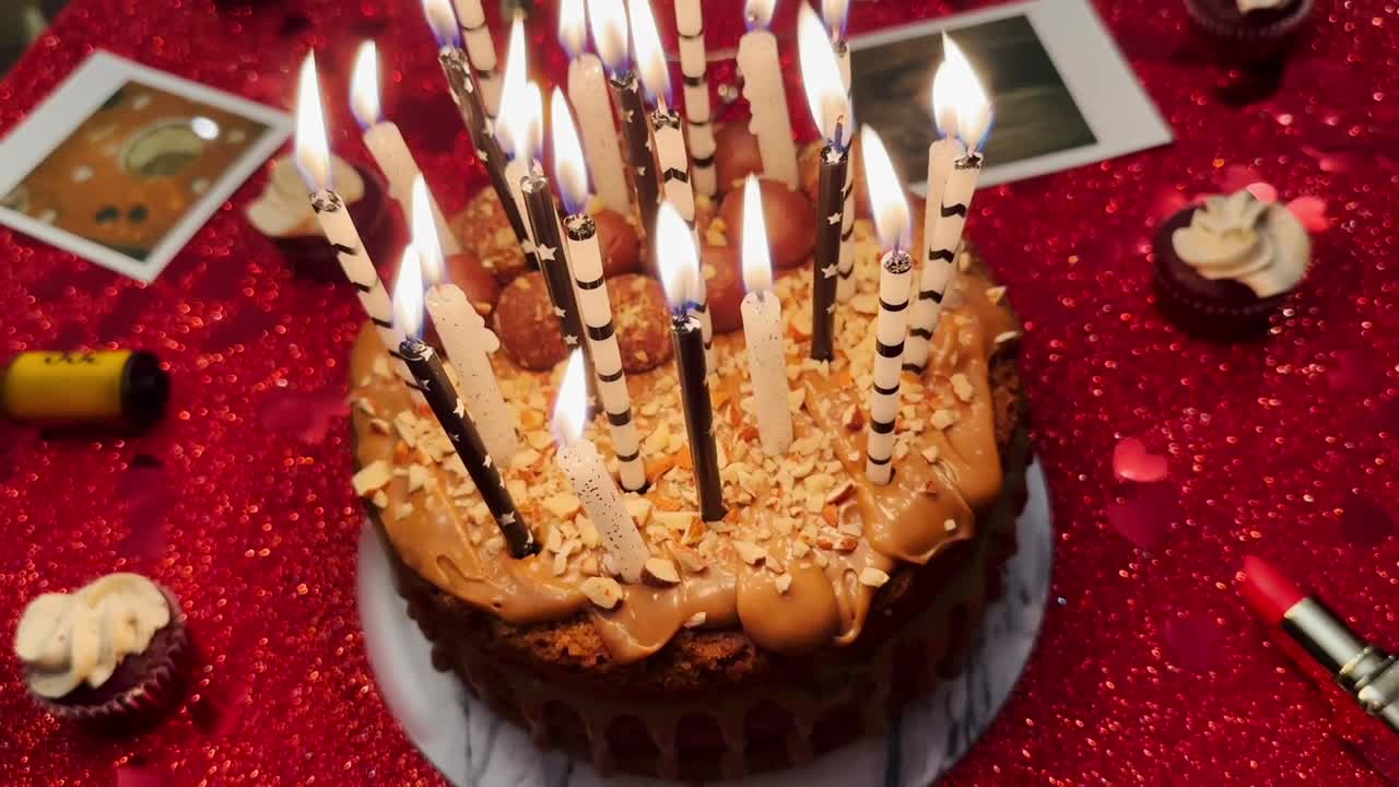 pastel de cumpleaños con velas y purpurina roja en el fondo, celebración de fiestas