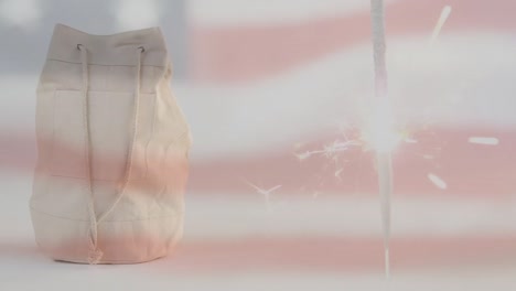 animation of red kaleidoscopic shapes over united states text, sparkler, bag and flag of america