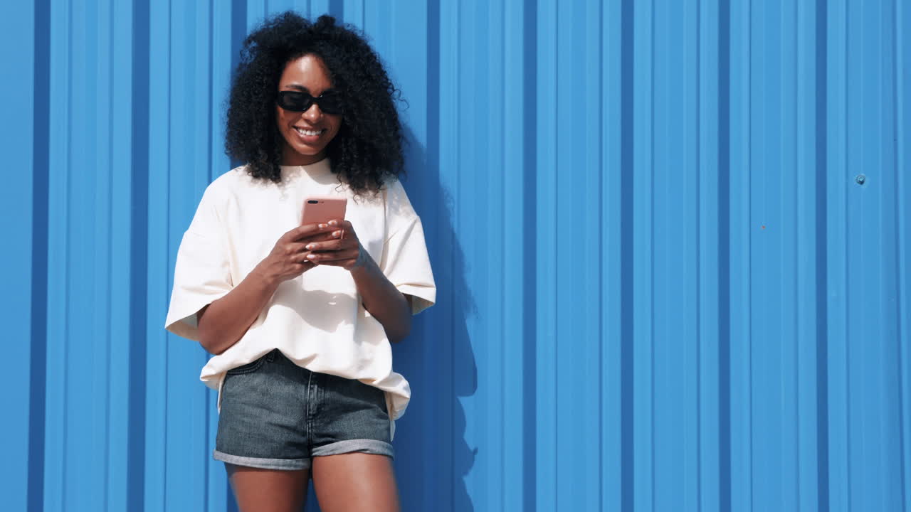 Donna che per mezzo del telefono all'aperto