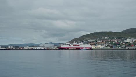 cruise ship docked on pier in norway with calm waters in foreground