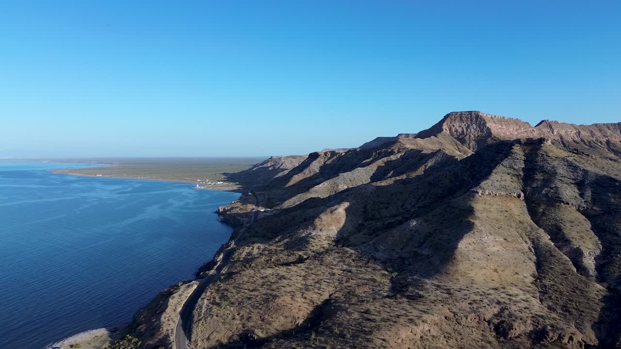 Bird's-eye view of some mountains where the ocean meets the desert.