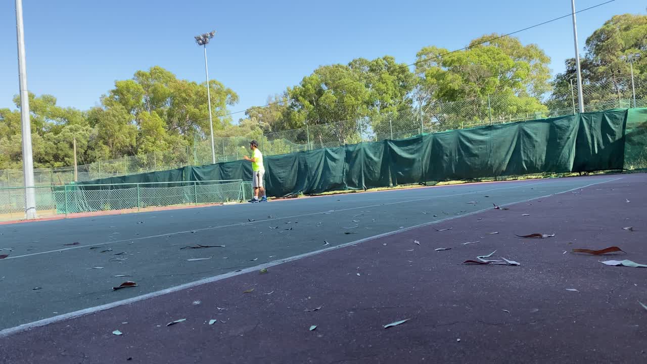 hombre golpeando una pelota de tenis amarilla con la raqueta