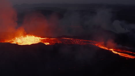 Forwards-fly-over-volcanic-landscape.-Aerial-view-of-active-crater-with-boiling-magma-running-off-in-stream.-Fagradalsfjall-volcano.-Iceland,-2021