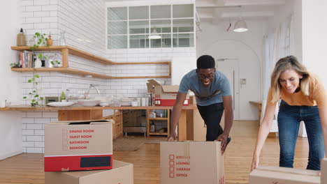 smiling young couple carrying boxes into new home on moving day