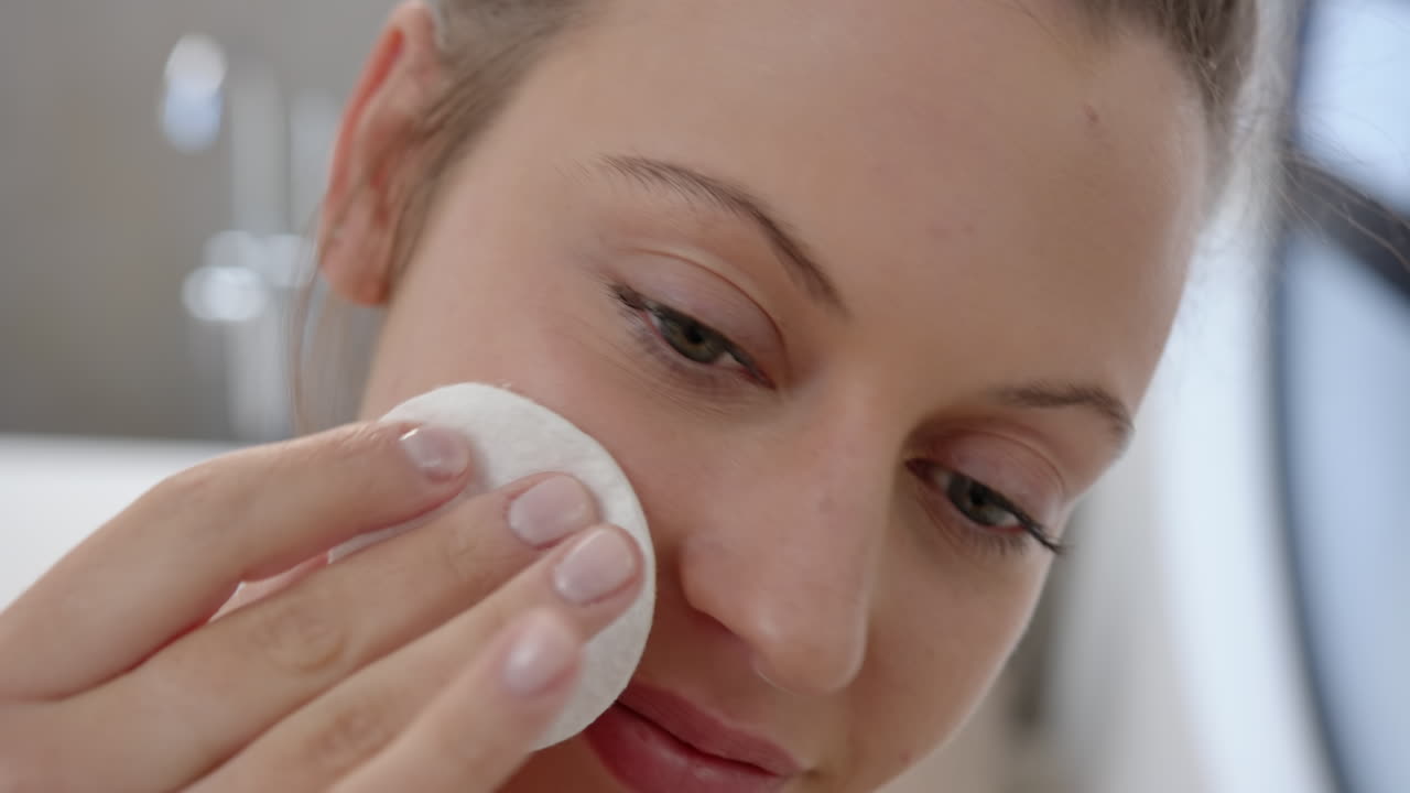 Applying facial cleanser, young woman enjoying skincare routine at spa