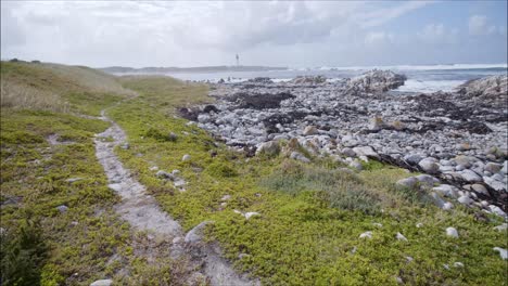 Sendero-Junto-A-La-Costa-Rocosa-Con-Faro-A-Distancia