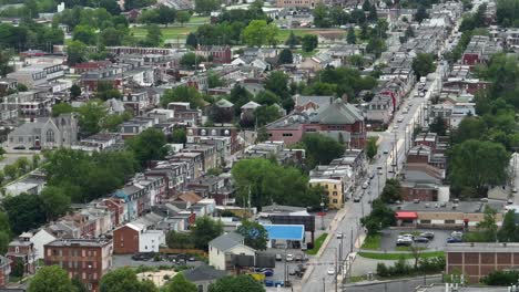 Tráfico-En-La-Calle-Principal-De-La-Ciudad-Americana-Con-Una-Larga-Hilera-De-Casas-En-El-Barrio