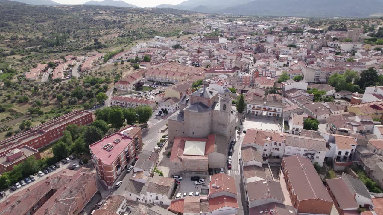 Aerial view circling San Mart&iacute;n de Valdeiglesias parish church among idyllic Spanish town neighbourhood streets