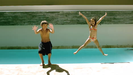 siblings jumping together in the swimming pool