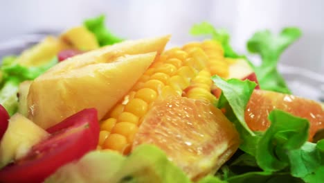 organic green salad with various kinds of fruits in rotating macro shot - healthy lifestyle