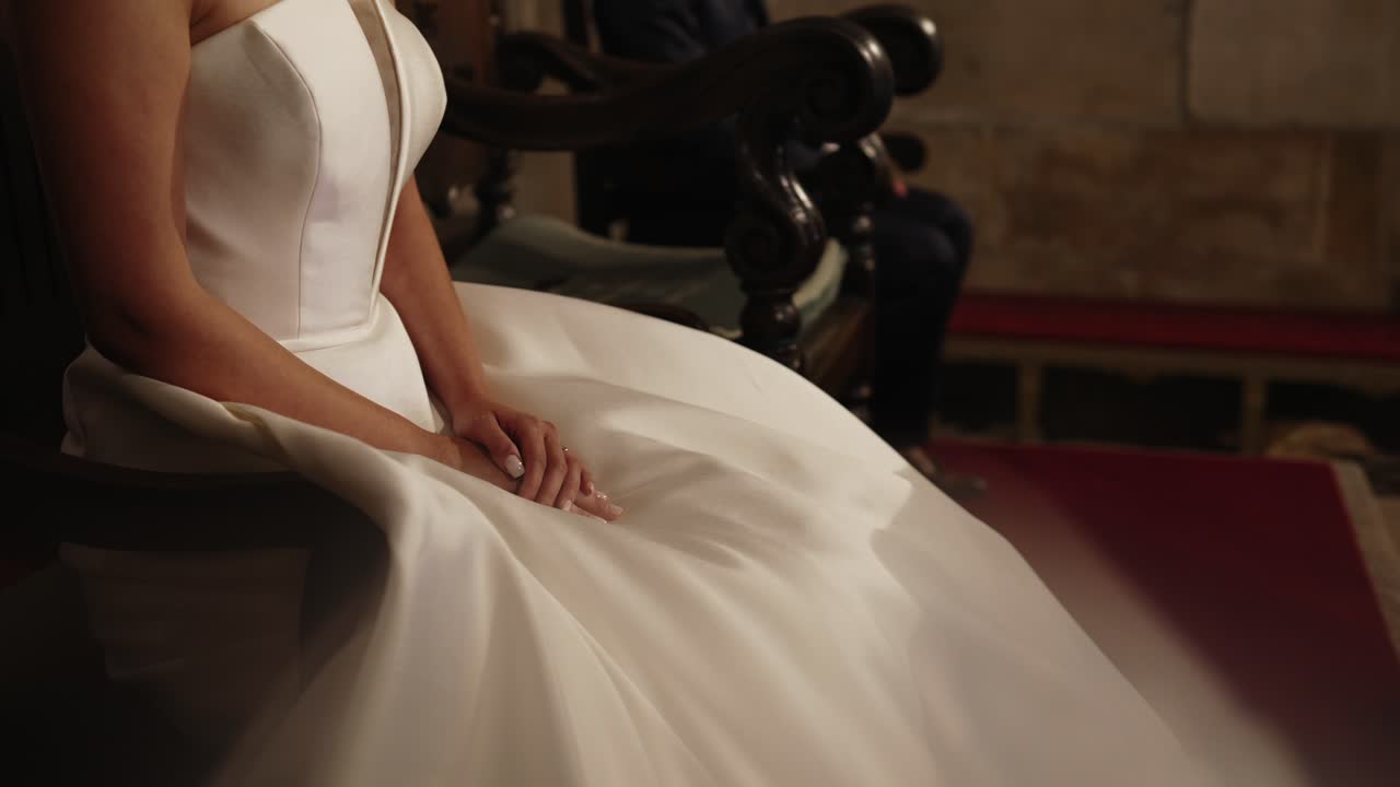 Elegante vestido de satén que fluye sobre dedos cuidados en un ambiente interior tranquilo