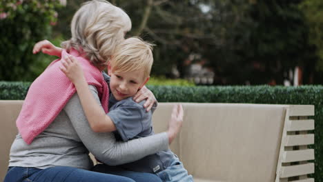 grandmother and grandson talking on a bench in the park
