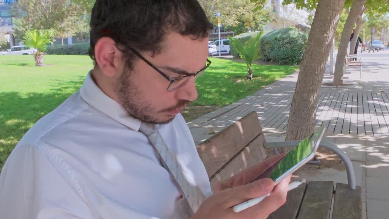 Primo piano di un uomo concentrato sul suo tablet digitale con stilo