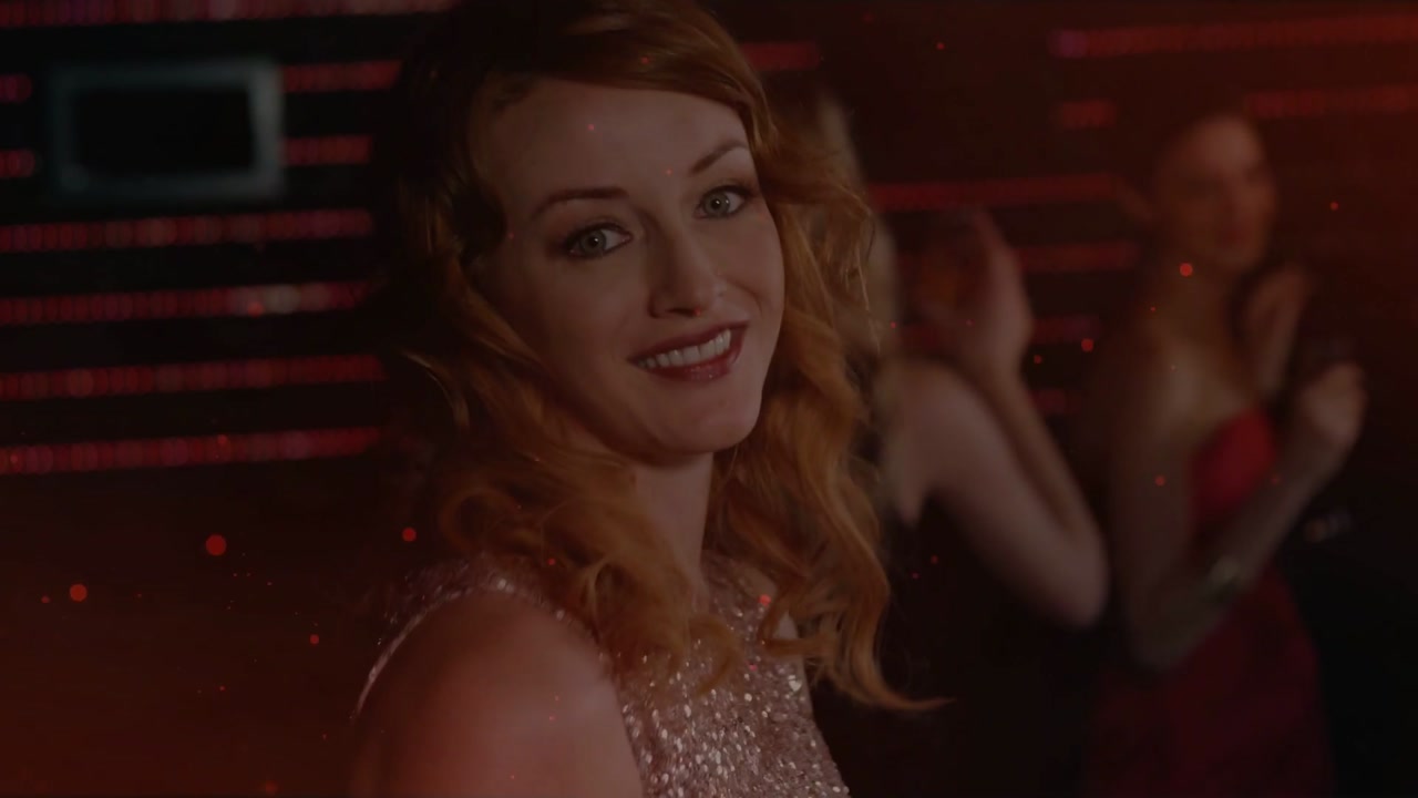 Woman holding flute and smiling at camera, celebrating while crowd cheering, club lights pulsing