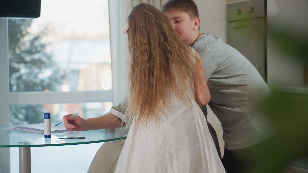 Young children hug their mom from the back while she sits on chair, then they sit in front of her after hugging, a heartwarming family moment with love and affection in a cozy indoor setting
