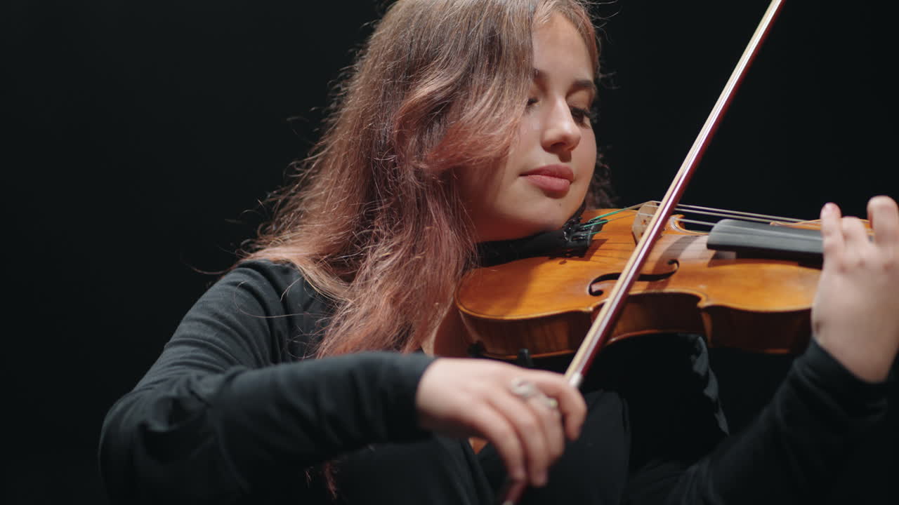 una mujer violinista está tocando el violín en la sala de música una joven violinista en la ópera