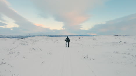 Camera-follows-a-female-cross-country-skier-on-a-ski-trail-on-a-snowy-mountain-in-the-northern-Sweden