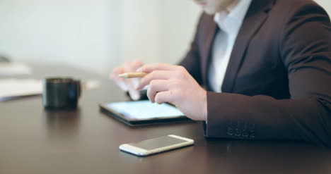 Man-Using-Tablet-In-Office-(Finance-Background)