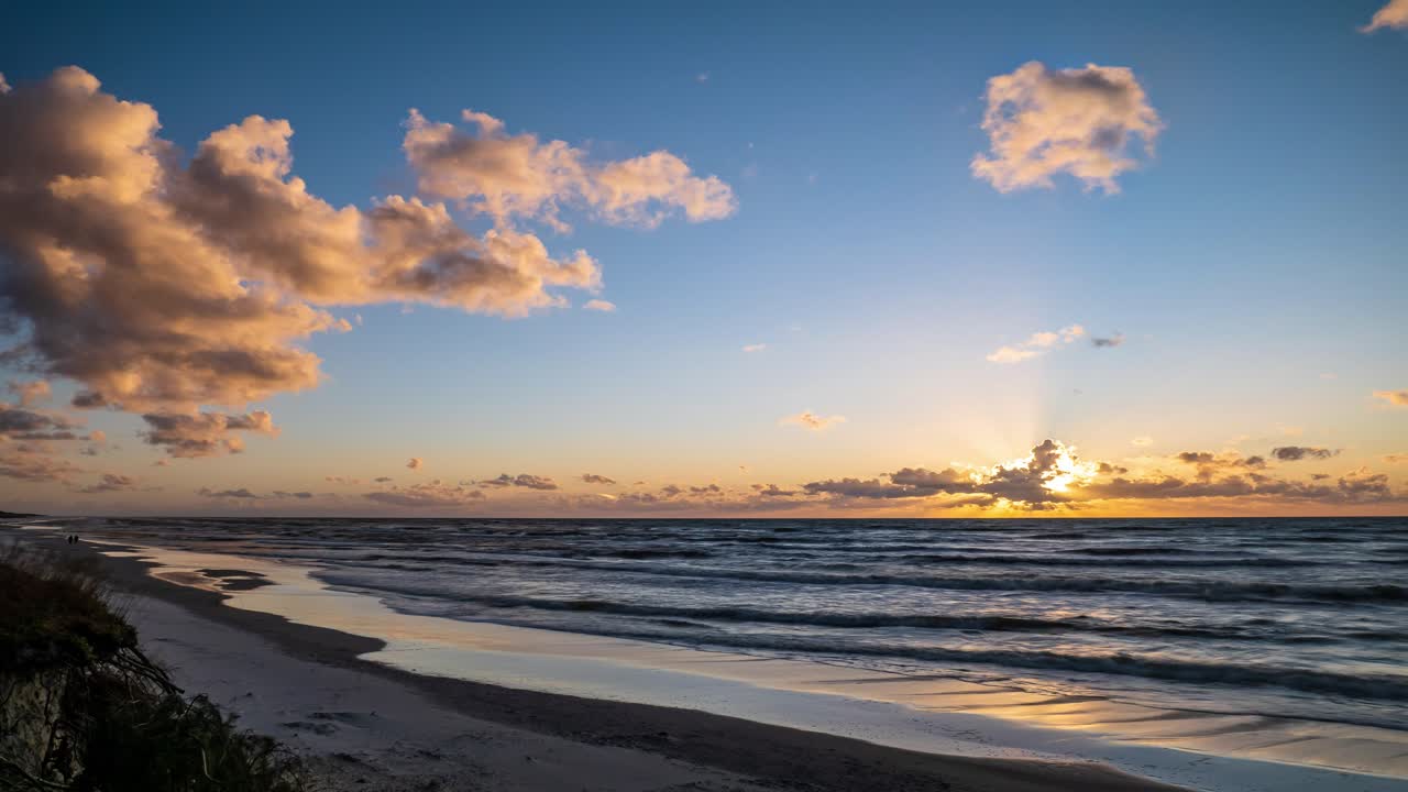 Time Lapse of Orange Cloudy Sunset Over Sea. Sun Shining Through Clouds.