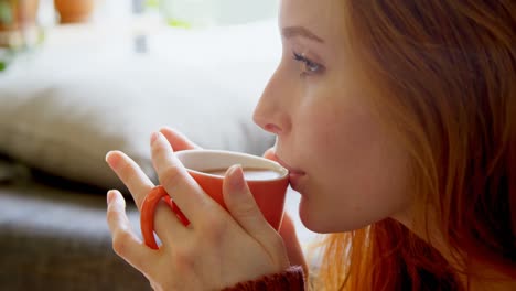 Woman-having-coffee-in-living-room-4k