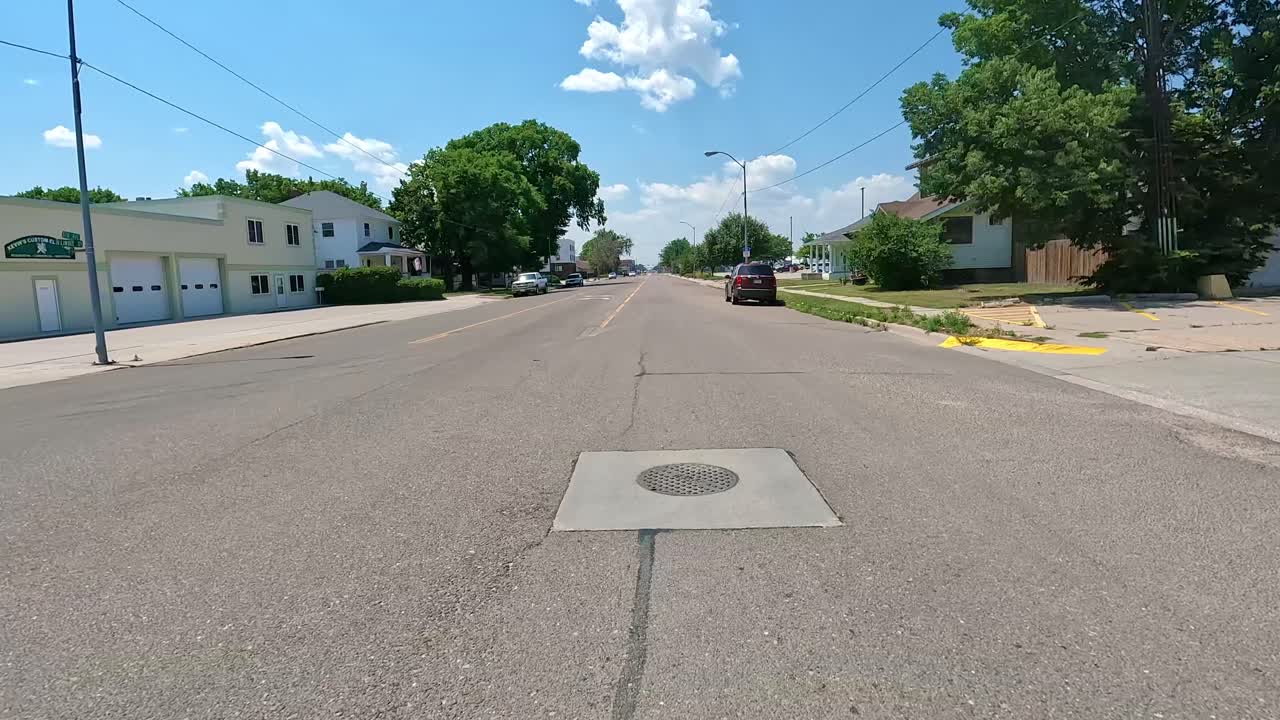 POV - Driving on a traditional main street on the outskirts of Midwestern town, driving past a fuel station and the local fiber optic internet provider ; hometown,