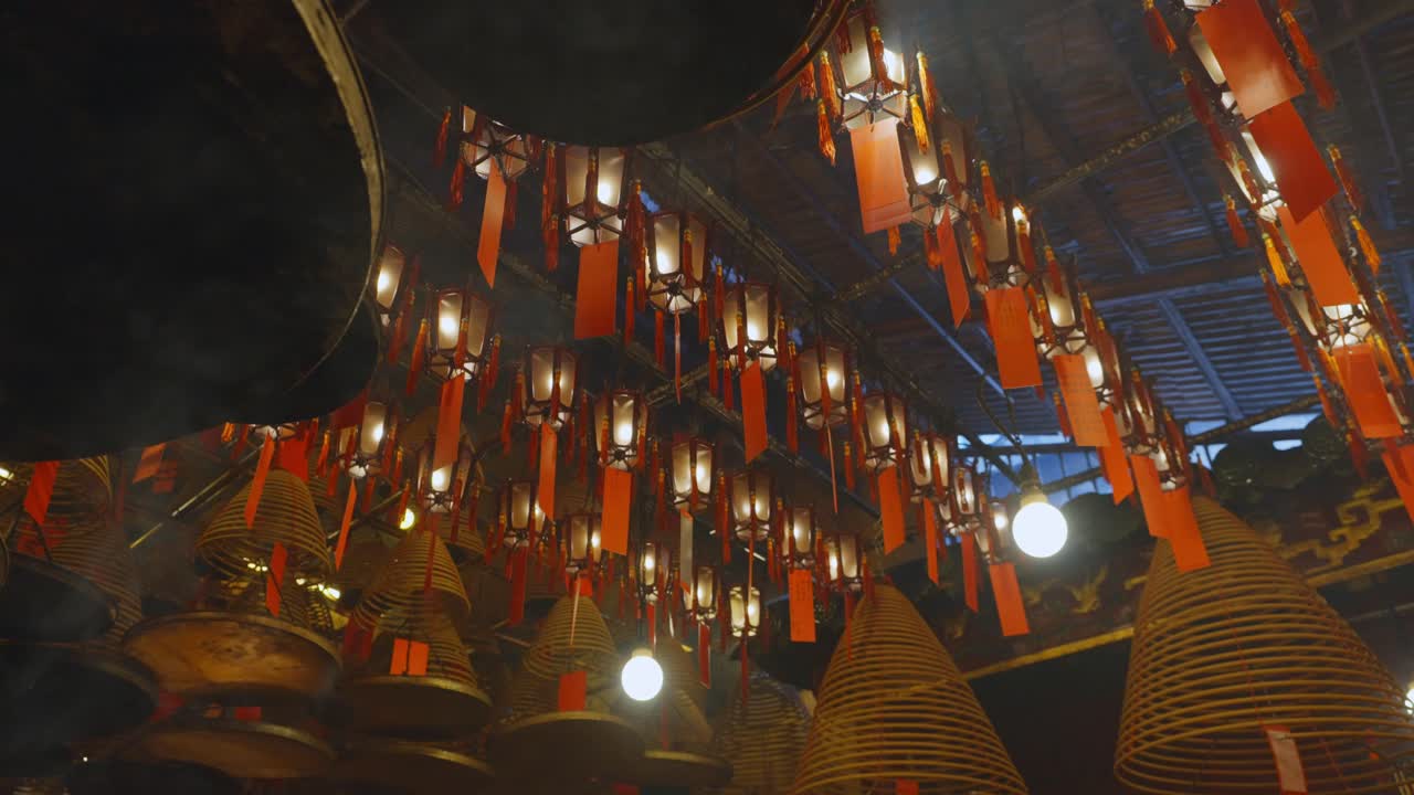 toma cinematográfica de inciensos circulares adheridos al techo ardiendo lentamente y difundiendo humo-3