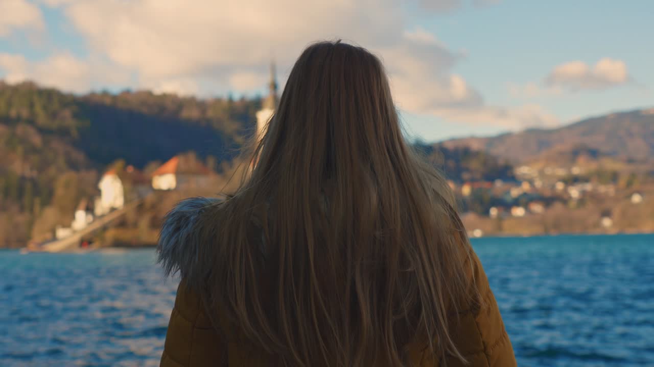 아름다운 젊은 백인 여성이 교회가 있는 섬을 바라보는 4k 비디오