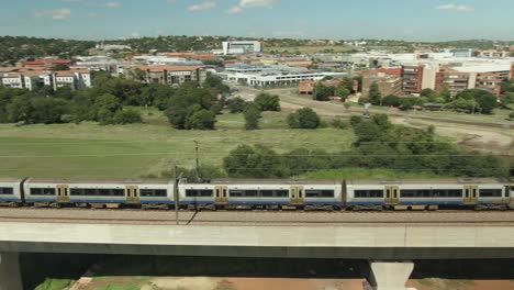 Drone-aerial-following-a-passing-high-speed-commuter-train-at-speed