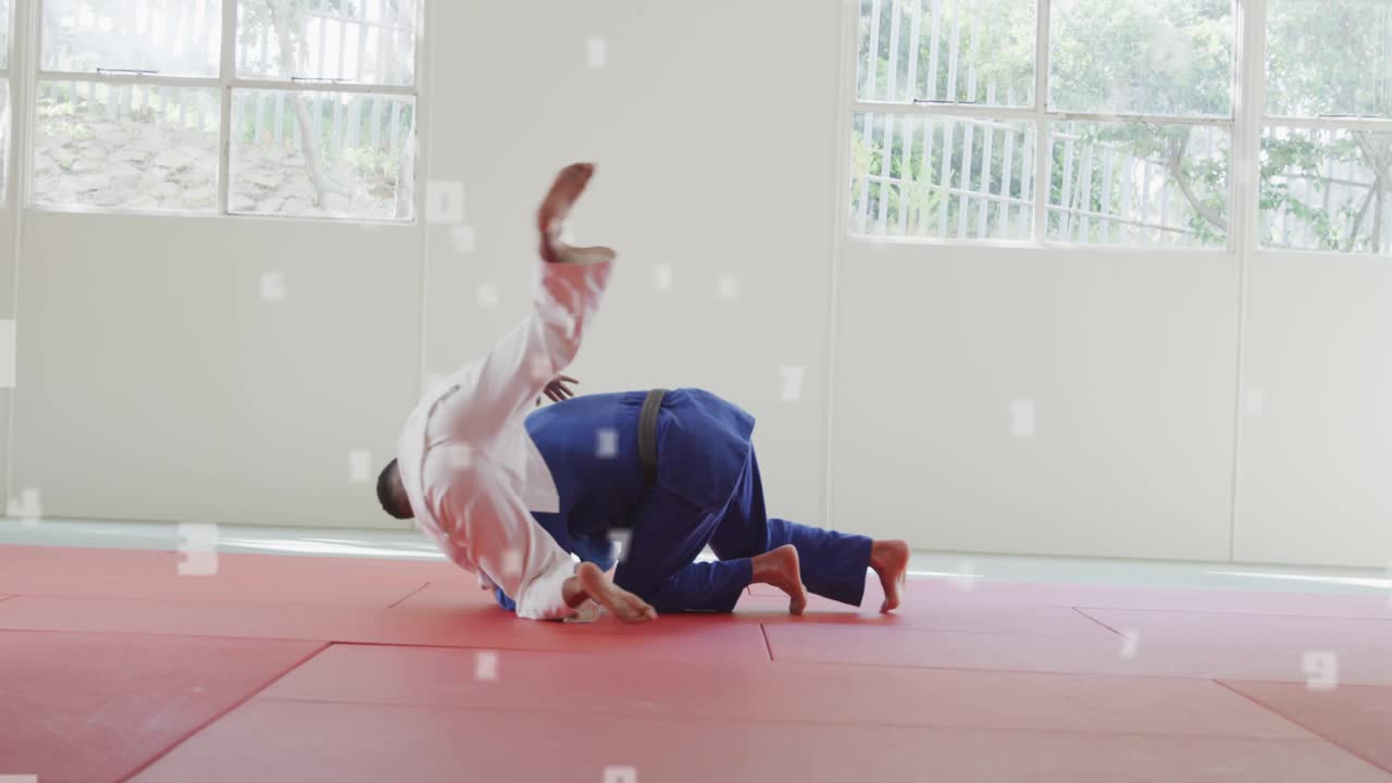 White-gi man breaking blue-gi balance with grip, loading and executing judo throw for training