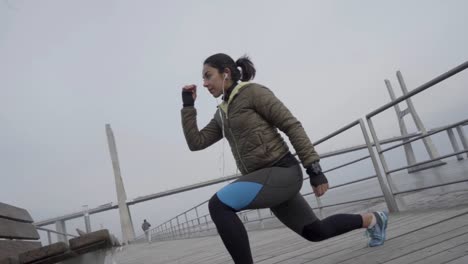 focused sporty hindu woman with ponytail training outdoor