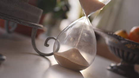 hourglass sand falling in slow motion paning up