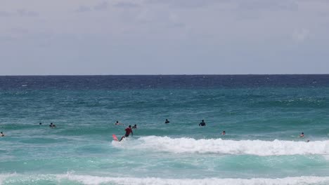 multiple surfers catching and riding ocean waves